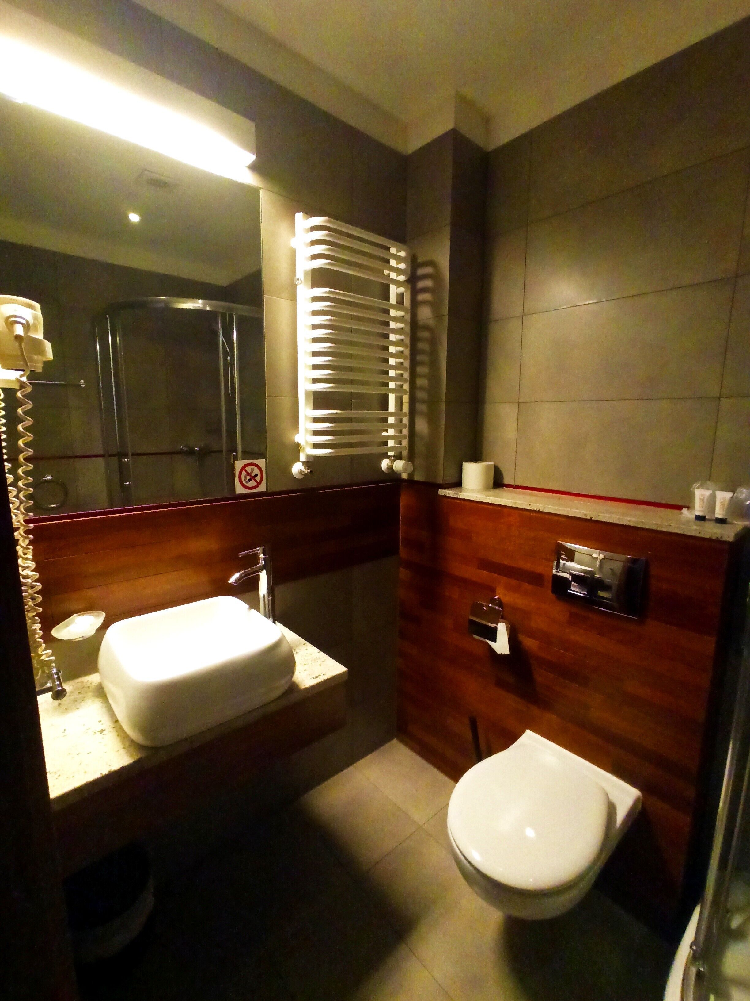 A modern bathroom with a sink, toilet, and a towel rack.