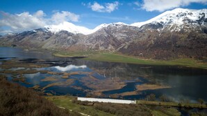 A mountainous landscape with a lake and snow-capped peaks. - Agriturismo Falode (Castello del Matese)