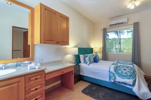 A bedroom with a bed, bedside table, lamp, and a large window with curtains. - Villa Agave Azul | 5BR Ocean View Villa | Pool, Jacuzzi & Golf Views (Cabo del Sol)