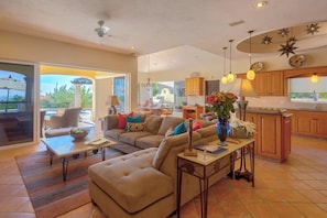 A spacious living area with a sofa, coffee table, and a view of the outdoors. - Villa Agave Azul | 5BR Ocean View Villa | Pool, Jacuzzi & Golf Views (Cabo del Sol)