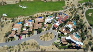 An aerial view of a residential area with houses, a golf course, and a swimming pool. - Villa Agave Azul | 5BR Ocean View Villa | Pool, Jacuzzi & Golf Views (Cabo del Sol)