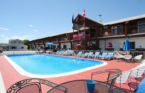 Piscine extérieure en saison, parasols, chaises longues