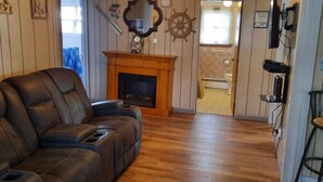 Ein Wohnzimmer mit einer Ledersofa, einem Kamin und Holzboden.