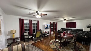 Una sala de estar con comedor, un sofá, una mesa de centro y un televisor.