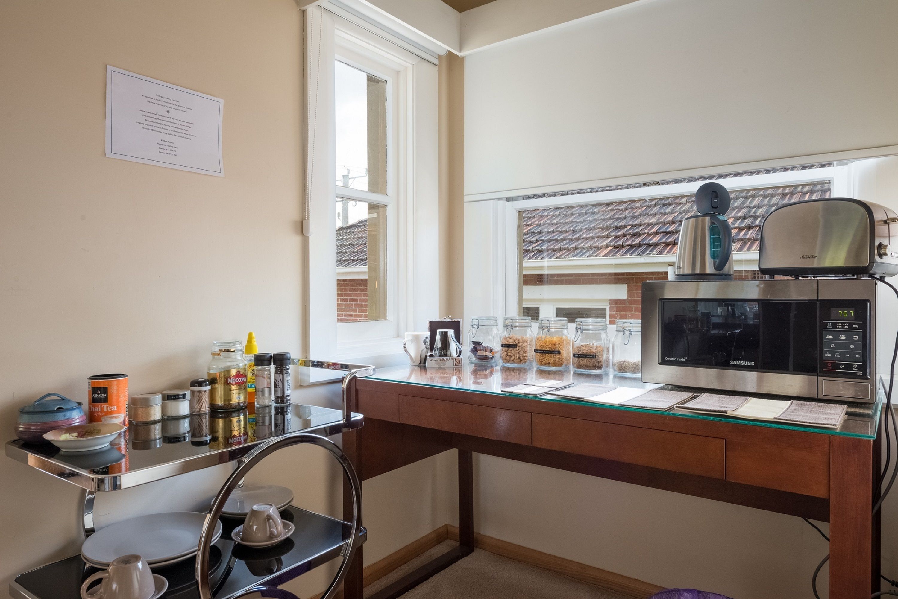 A kitchen with a microwave, a coffee maker, and various kitchen items on the counter.