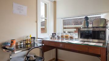 A kitchen with a microwave, a coffee maker, and various kitchen items on the counter.