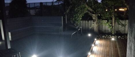 Ein Terrassenbereich im Freien mit Holzboden und Metallgeländer.