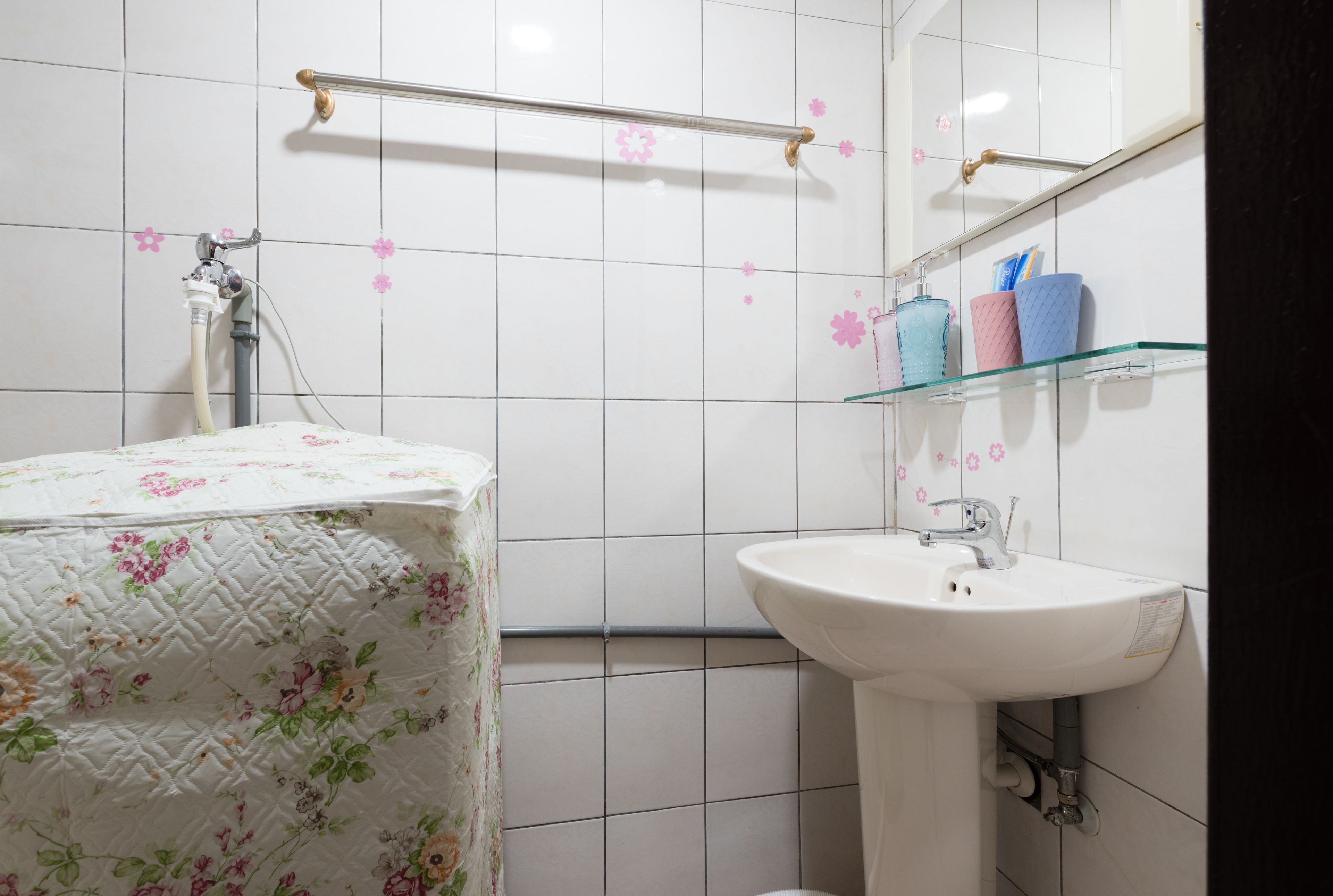 A bathroom with a white sink, a shower with a glass enclosure, and a toilet.