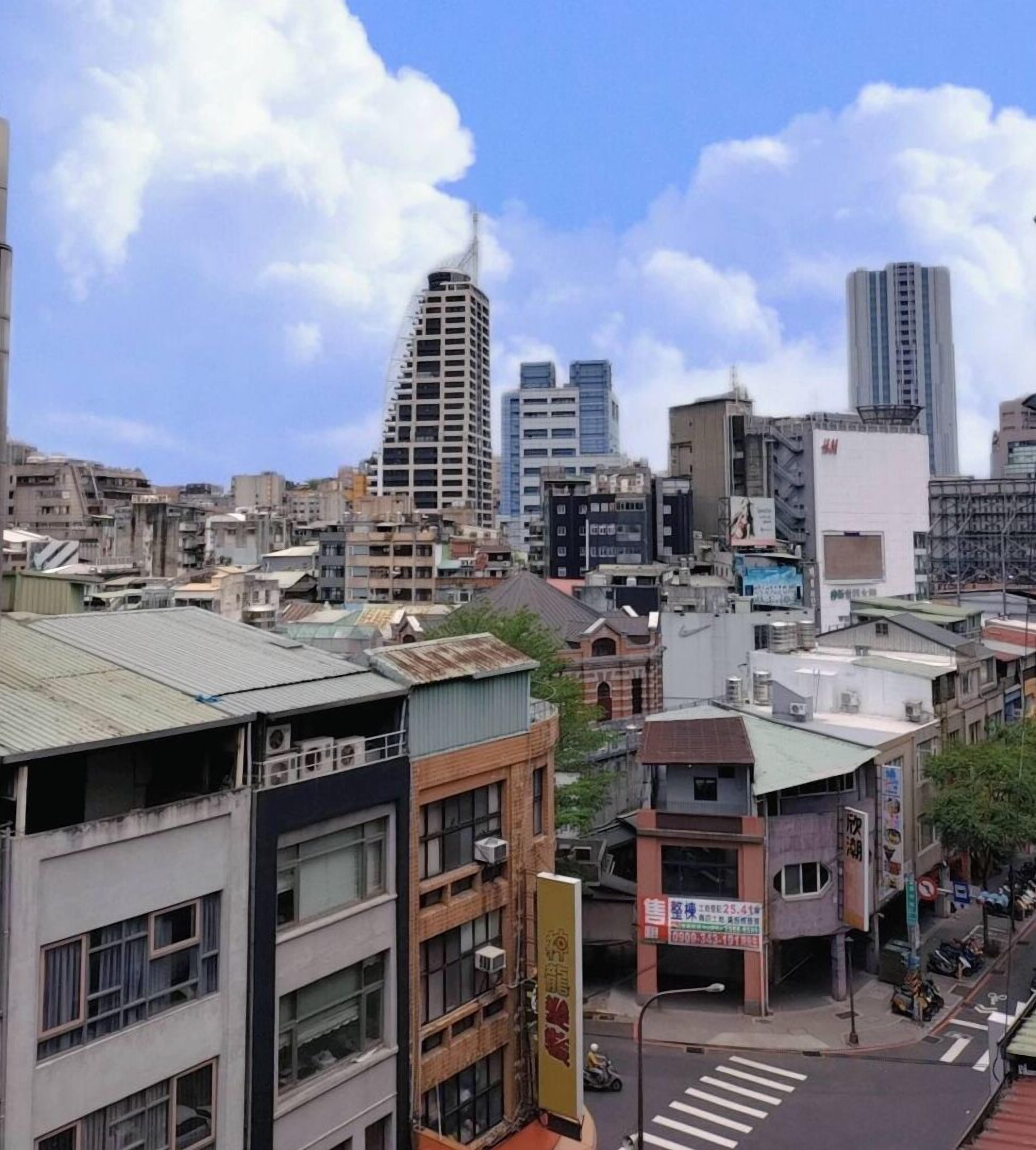 A cityscape with various buildings, including a distinctive curved skyscraper and several modern high-rises.