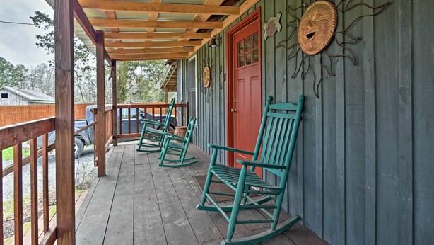 A wooden porch with rocking chairs and a red door. - Remote Kentucky Cabin w/ Fire Pit & 2 Ponds (New Concord)