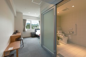 A hotel room with a desk, bed, and a shower area. - Morinoyu Resort (Beppu)