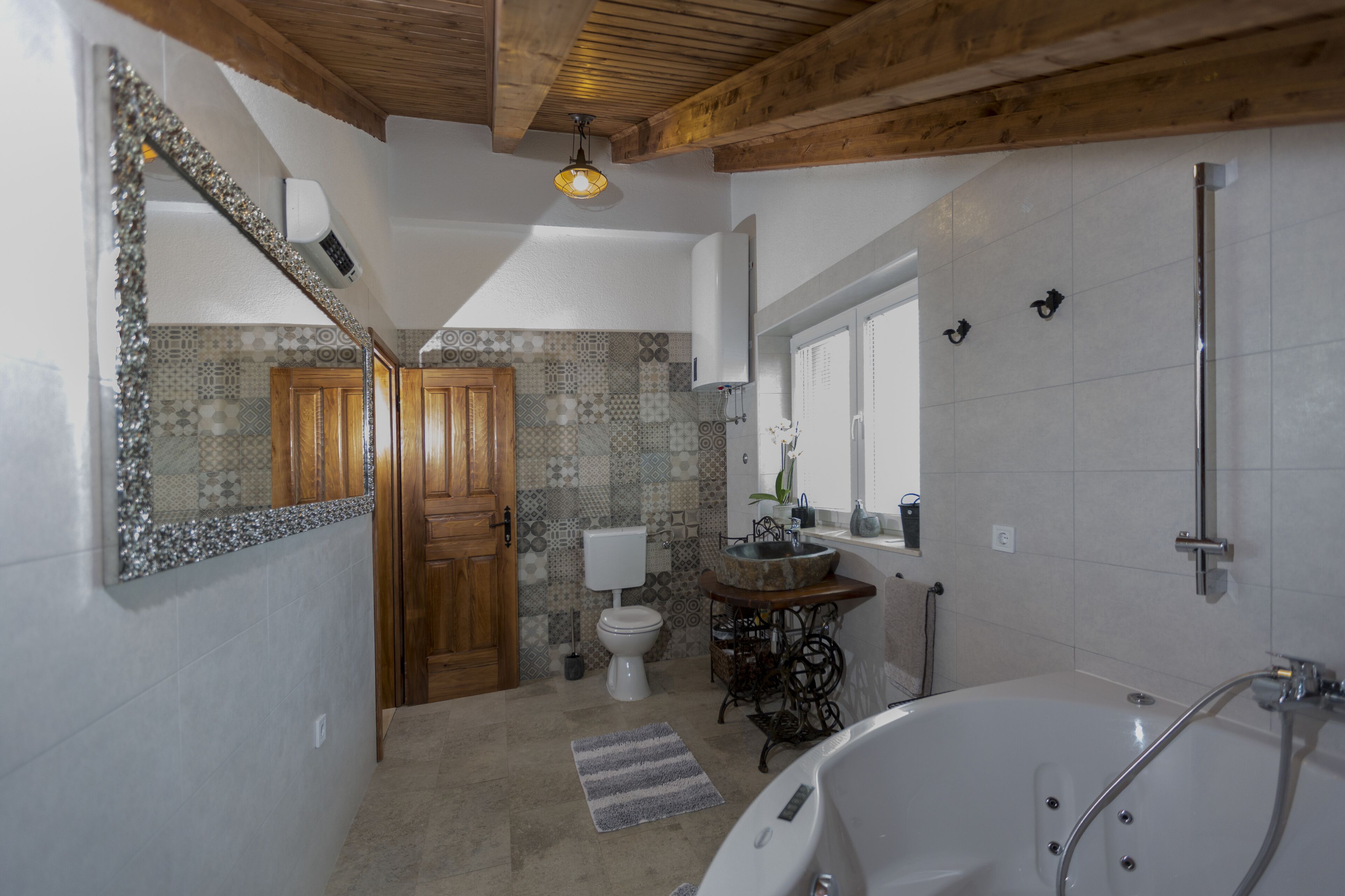 Ein Badezimmer mit Badewanne, Toilette, Waschbecken und Spiegel.
