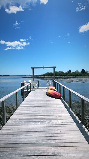 Un muelle de madera se adentra en aguas tranquilas bajo un cielo despejado.