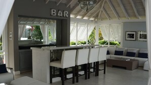 Una cocina moderna con barra, muebles blancos y vistas a zonas verdes.
