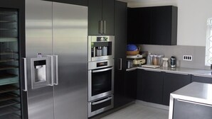 Una cocina moderna con electrodomésticos de acero inoxidable, armarios negros y un horno empotrado.
