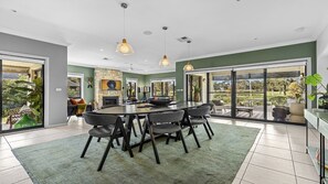 A modern dining area with a round table, chairs, and a view of the outdoors.
