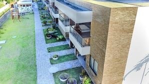 Un hotel moderno con terraza en la azotea, piscina y jardín.