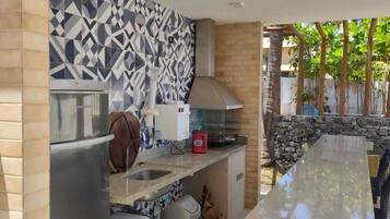 Una cocina de diseño moderno, con un salpicadero estampado, horno empotrado y pared de piedra.