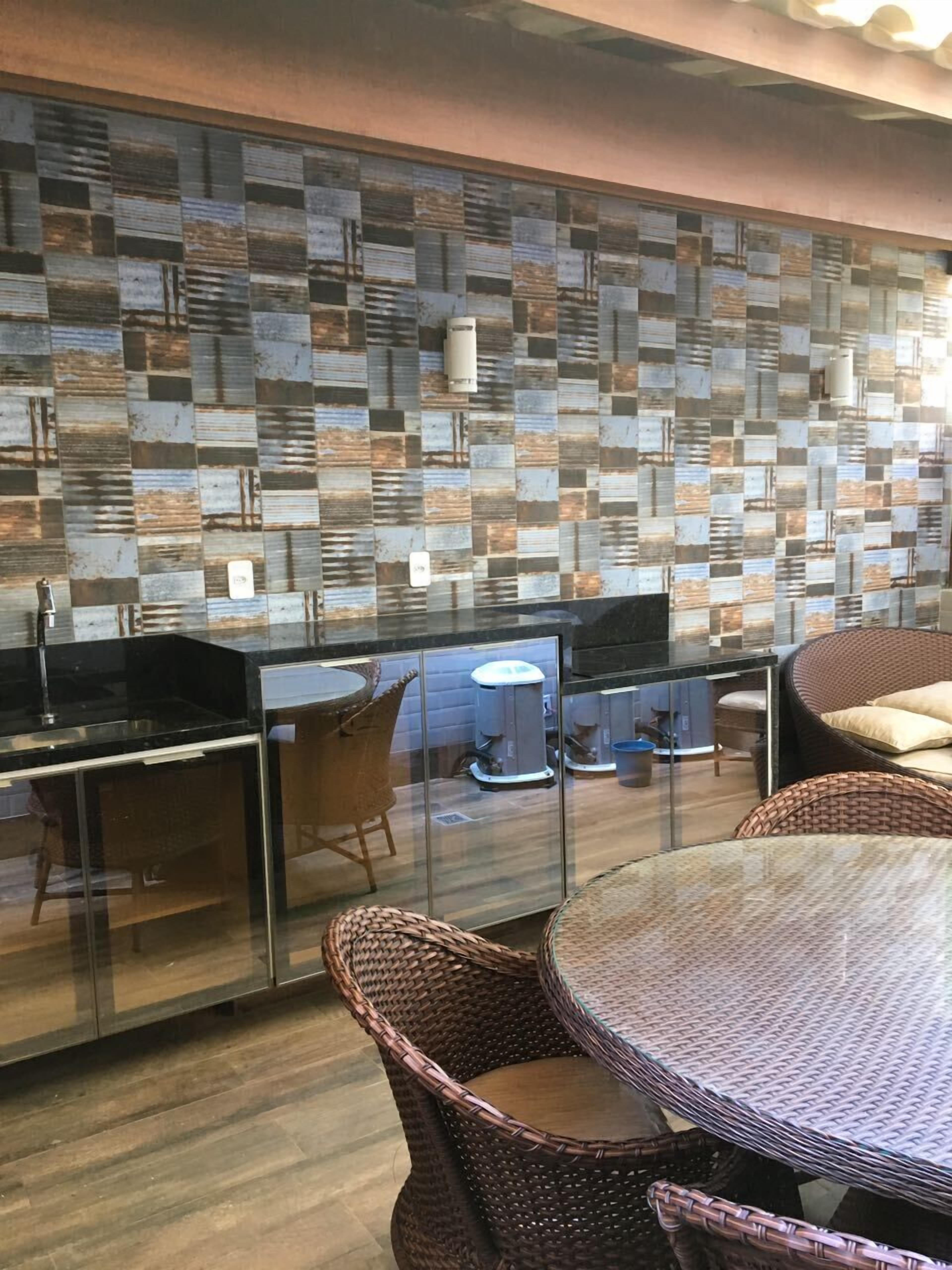 Eine moderne Küche mit Mosaik-Spritzschutz, Kabinetten mit Glastüren, Korbmöbeln und einem runden Esstisch.