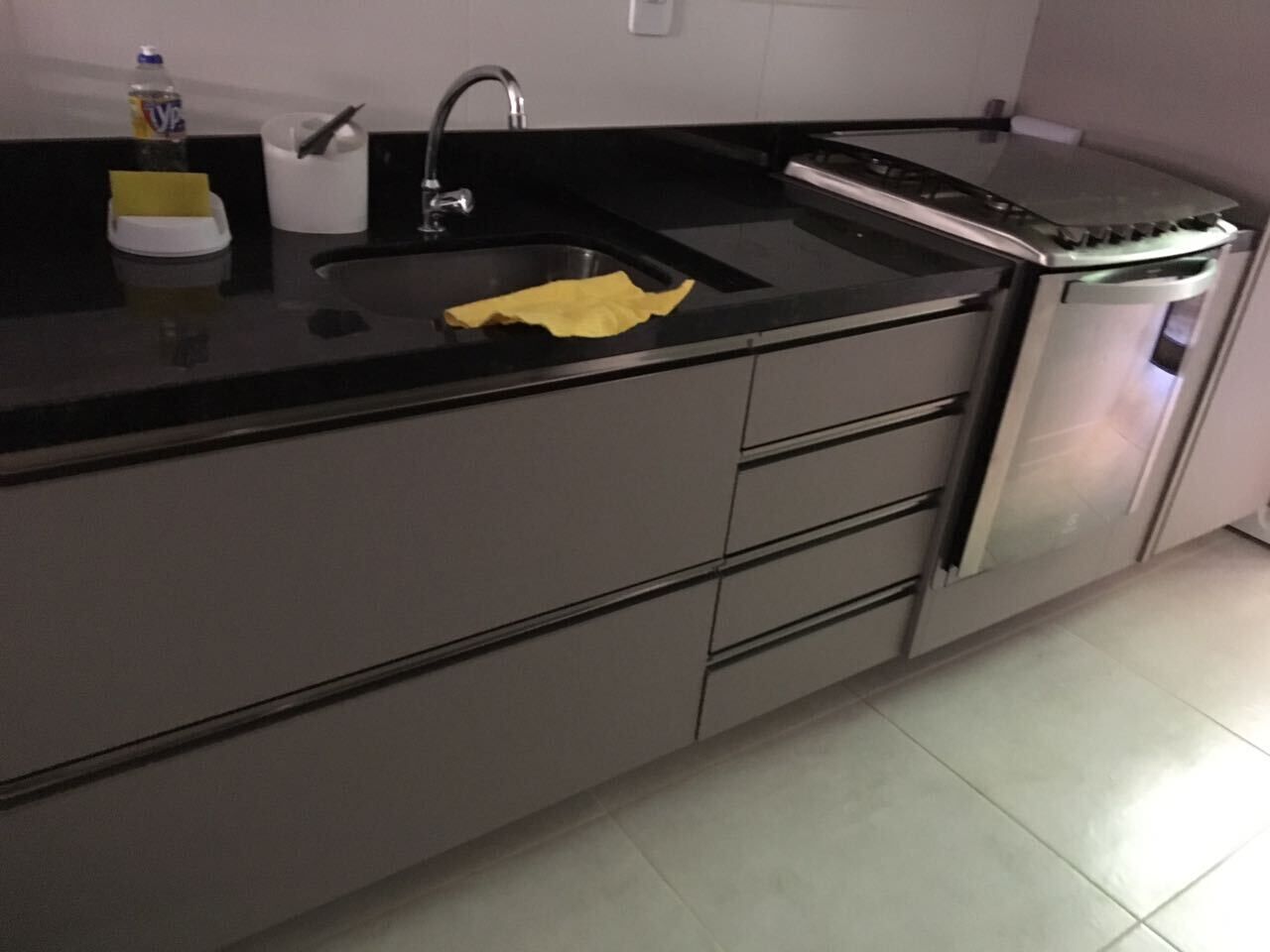 A modern kitchen with a stainless steel countertop, a sink, and a built-in oven.