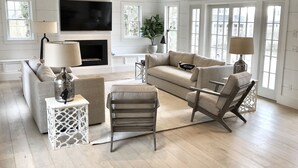 A spacious living room with a fireplace, large windows, and a modern design. - Stunning In-Town Home With Stone Hot Tub - Plunge Pool (Nantucket)