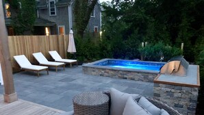 A backyard with a hot tub, lounge chairs, and a wicker sofa. - Stunning In-Town Home With Stone Hot Tub - Plunge Pool (Nantucket)