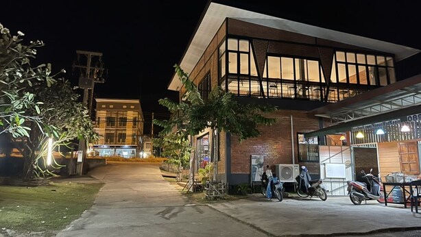 Un edificio moderno con un amplio frente de vidrio y una sección inferior de ladrillo.