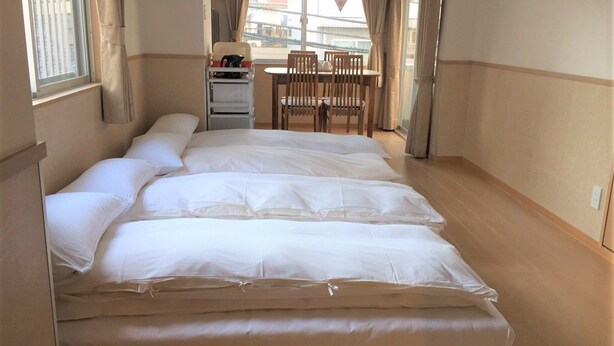 A room with a large bed, a desk, and a chair. - uenohouse annex (Tokyo)