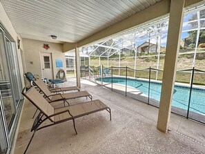 A covered outdoor area with lounge chairs and a pool. - Capteeva Villa - Private Pool/Spa, 24/7 Support! (Davenport)