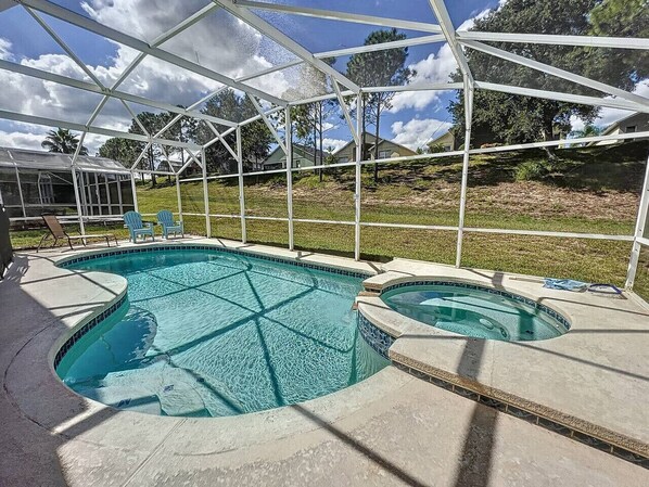 A swimming pool with a glass enclosure, two hot tubs, and lounge chairs. - Capteeva Villa - Private Pool/Spa, 24/7 Support! (Davenport)