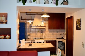 A compact kitchen with a central island, a sink, and overhead lighting.