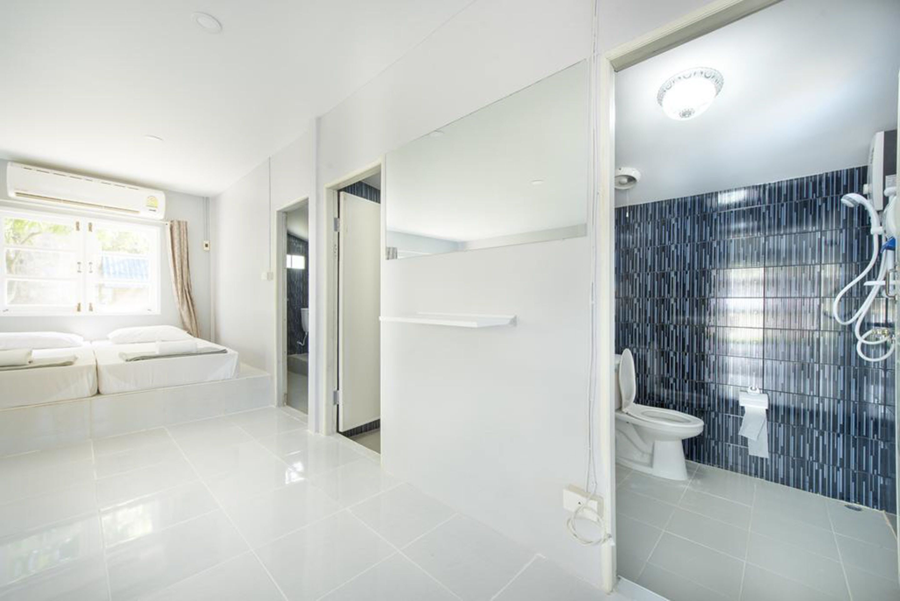 Ein modernes Hotelbad mit Dusche, Toilette und einem großen Spiegel.
