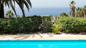 A swimming pool with a view of the ocean and palm trees. - CHARMING VILLA NEAR THE SEA, SEA VIEWS. CLIMATIZED POOL. AC AND WIFI FREE (Callao Salvaje)