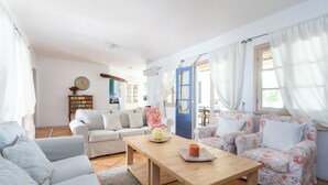 A spacious living room with a wooden coffee table, two sofas, and a blue door leading to a balcony. - CHARMING VILLA NEAR THE SEA, SEA VIEWS. CLIMATIZED POOL. AC AND WIFI FREE (Callao Salvaje)