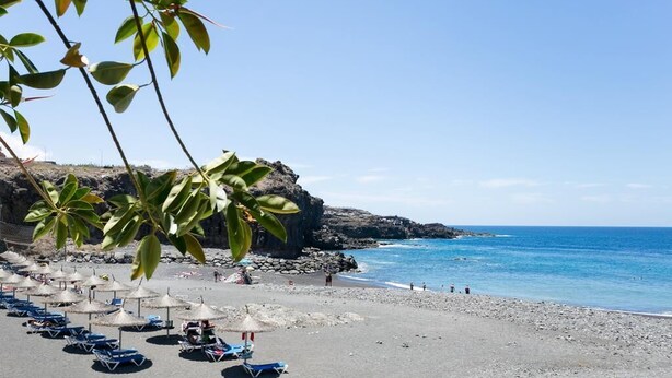 A beach with umbrellas and lounge chairs, rocky cliffs, and the ocean. - CHARMING VILLA NEAR THE SEA, SEA VIEWS. CLIMATIZED POOL. AC AND WIFI FREE (Callao Salvaje)