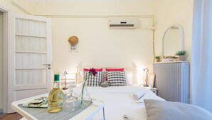 Ein ordentlich eingerichtetes Schlafzimmer mit Bett, Nachttischen, Heizkörper und einem Fenster mit Vorhängen.
