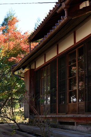 Un edificio japonés tradicional con amplios puertas correderas y techo de tejas.