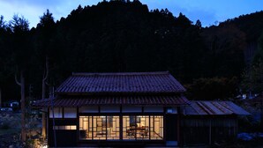 A traditional Japanese house with a tiled roof, large windows, and a wooden exterior. - The Lodge MIWA (Kyoto)