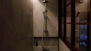 A narrow shower area with a built-in window, a showerhead, and a handheld shower attachment. - The Lodge MIWA (Kyoto)