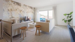 A modern living room with a TV, two sofas, a coffee table, and a plant. - Serene Horizon - BY SCH (Nazaré)