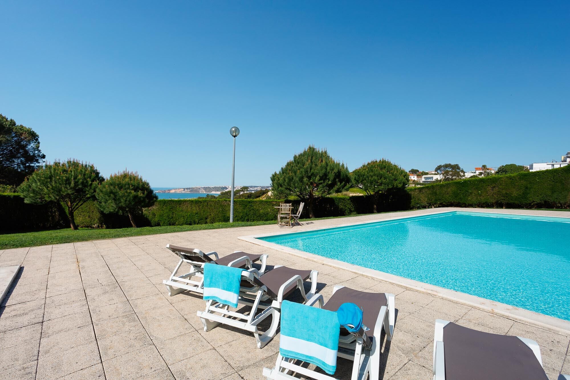 A swimming pool with lounge chairs and a lamp post.