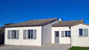 Un bâtiment à deux étages, doté d’un toit recouvert de tuiles, d’un petit balcon et d’une porte.