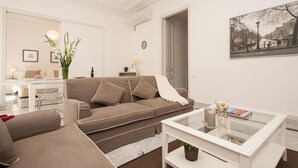 A modern living room with a sofa, coffee table, and a painting of a cityscape. - Large two bedroom apartment (Barcelona)