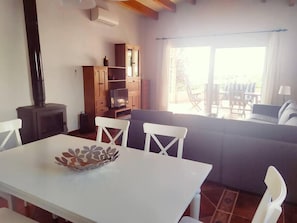 Relax in this inviting living space with a dining area, featuring a cabinet, TV, and comfortable seating.