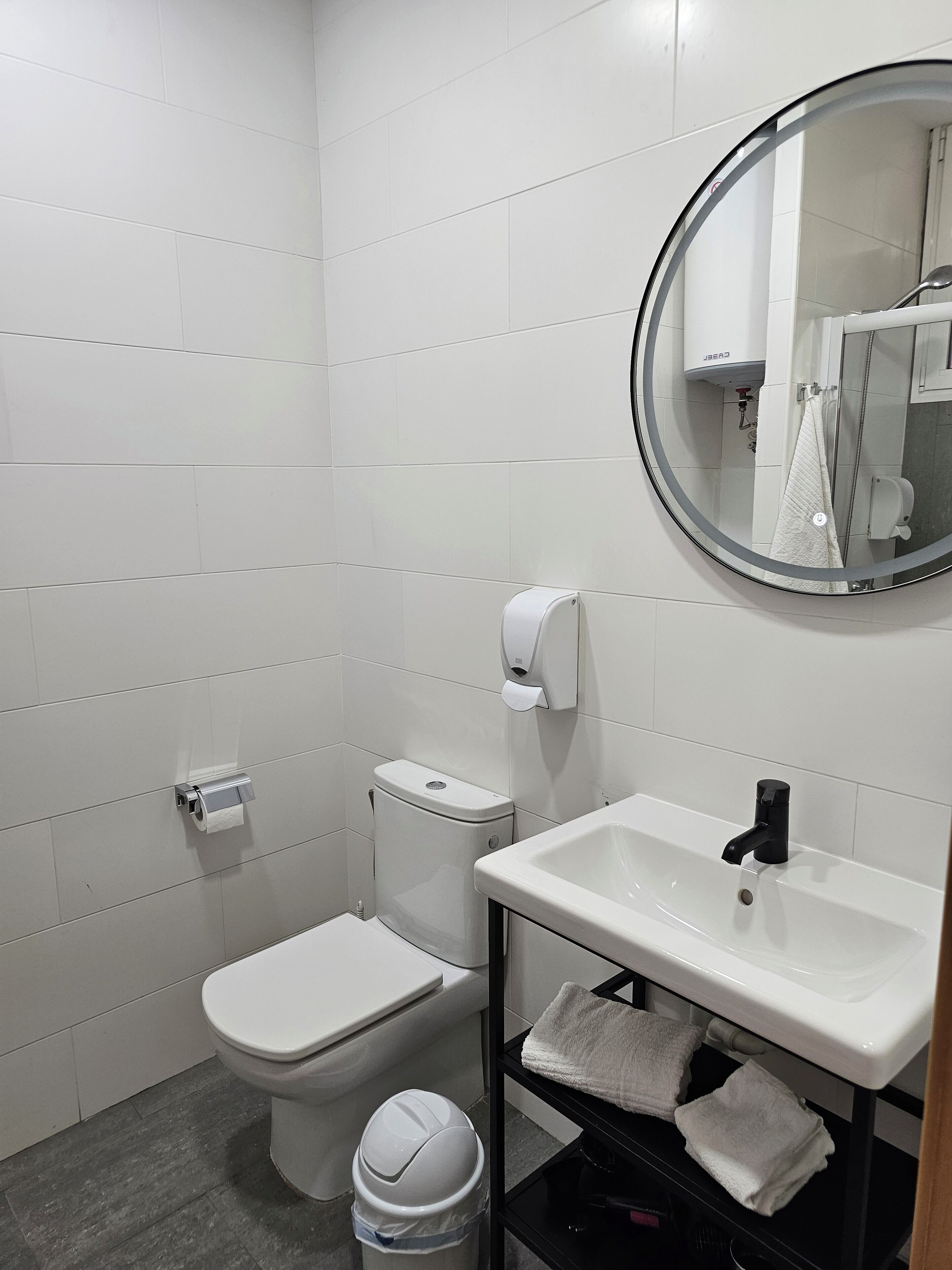 Une salle de bain moderne avec des toilettes, un lavabo et un miroir.