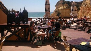 An outdoor patio with tables and chairs, overlooking a cliff and the sea. - L&A VILLA- with private Salt pool-3 bedrooms w/ AC, Heated Pool (optional) (Portimão)