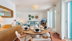 Un coin repas avec une table ronde, des chaises et un canapé en arrière-plan.