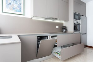 Una cocina moderna con electrodomésticos integrados, lavavajillas y cafetera.