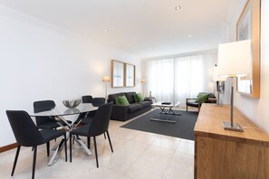 Una sala de estar moderna con comedor, un sofá, una mesa de centro y una lámpara.