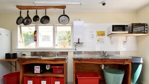 A kitchen with wooden countertops, a window with a view, and various kitchen appliances. - Rucksacker Backpacker Hostel (Christchurch)